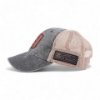 Left side profile of gray and tan mesh trucker cap showing curved brim and leather FNH Firearms patch